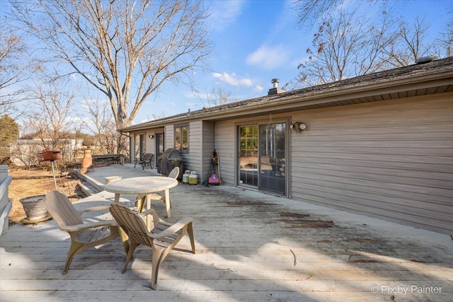 deck with outdoor dining space and area for grilling