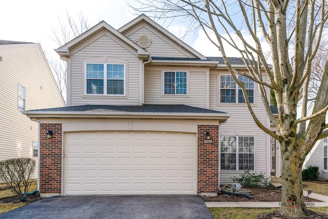 traditional home with aphalt driveway, brick siding, and a garage