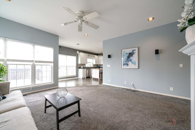 living area featuring dark colored carpet, baseboards, recessed lighting, and a ceiling fan