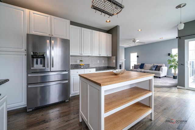 kitchen with decorative backsplash, plenty of natural light, stainless steel fridge, and butcher block counters