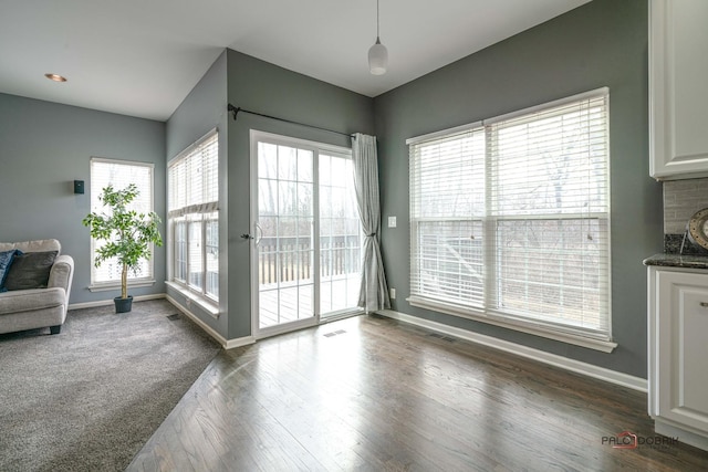 interior space with visible vents, baseboards, and dark wood-style floors