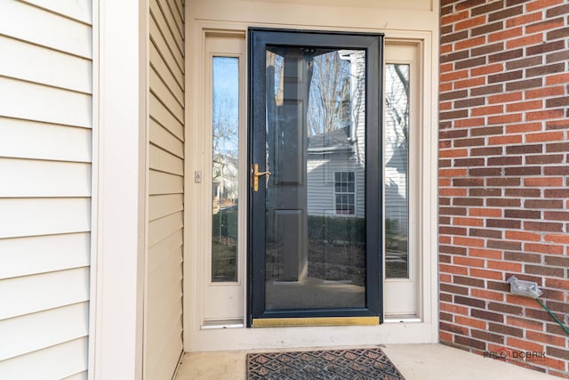 view of exterior entry with brick siding