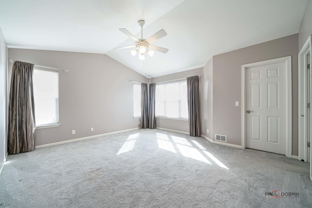 spare room with visible vents, lofted ceiling, carpet floors, baseboards, and ceiling fan