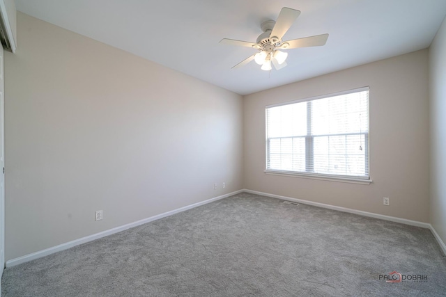 carpeted empty room featuring baseboards and ceiling fan