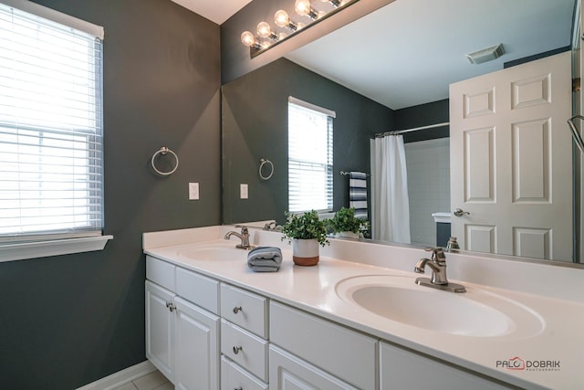 bathroom featuring double vanity, baseboards, visible vents, and a sink