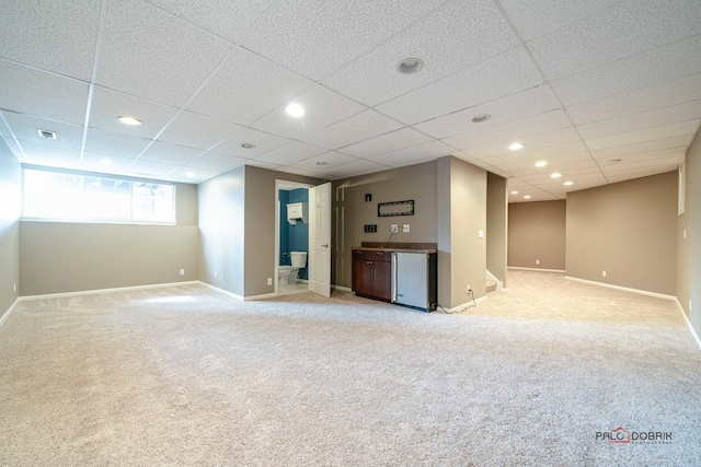 unfurnished living room featuring visible vents, light carpet, a drop ceiling, recessed lighting, and baseboards