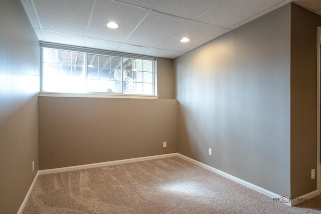 carpeted spare room with recessed lighting, a drop ceiling, and baseboards