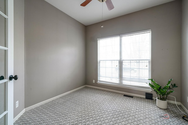 empty room with visible vents, baseboards, a ceiling fan, and carpet flooring