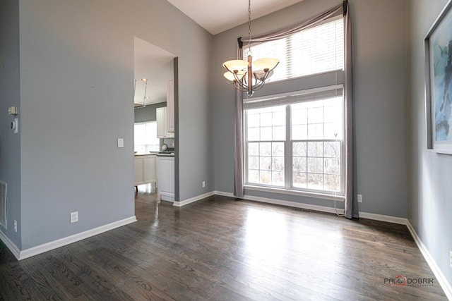 empty room with visible vents, baseboards, a chandelier, and dark wood-style flooring