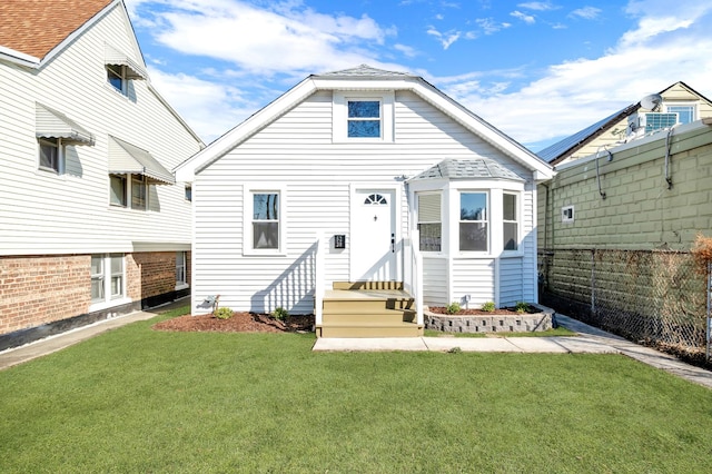 rear view of property with a yard and fence