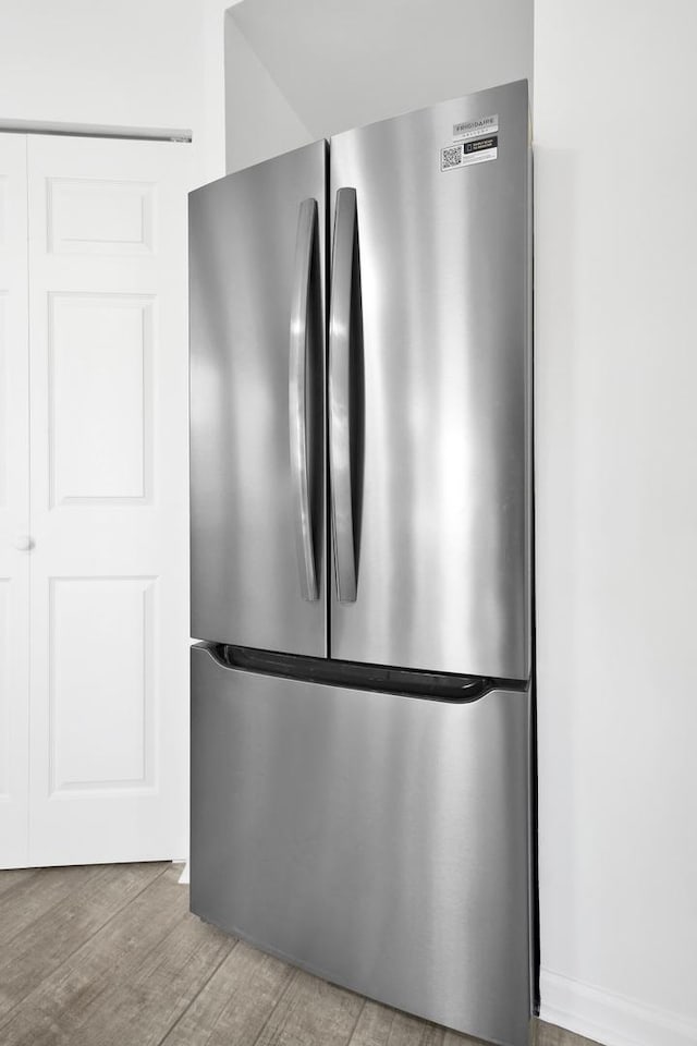 interior details featuring wood finished floors and freestanding refrigerator