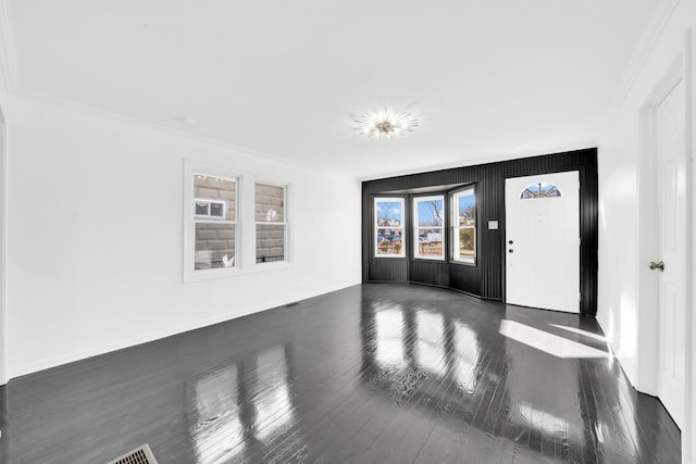 interior space with baseboards, wood finished floors, and crown molding