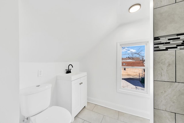 bathroom with tile patterned floors, toilet, lofted ceiling, baseboards, and vanity