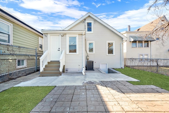 rear view of house with a patio, cooling unit, fence, a yard, and entry steps