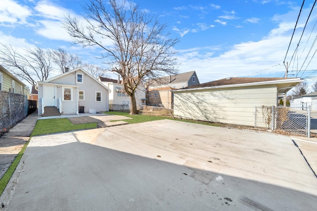 rear view of house with a patio, entry steps, and fence