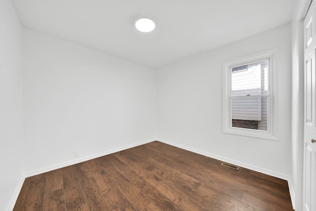 unfurnished room with dark wood finished floors, baseboards, and visible vents