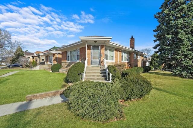 view of front facade featuring brick siding, a chimney, and a front lawn