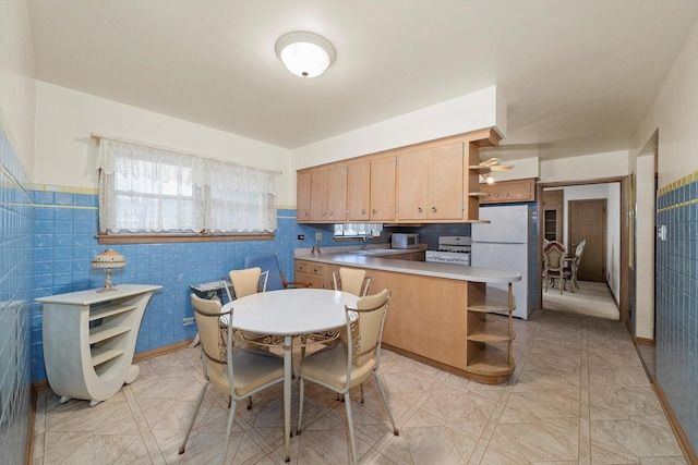 kitchen with open shelves, white appliances, tile walls, and a peninsula