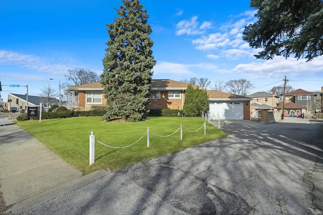 view of front of house featuring a front yard, a garage, brick siding, and a residential view