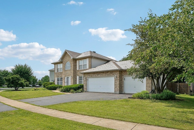 view of front of house featuring brick siding, an attached garage, driveway, and a front lawn