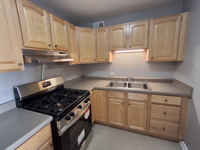 kitchen with under cabinet range hood, a sink, light brown cabinets, and gas stove