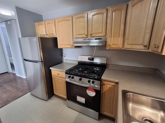 kitchen with a sink, light brown cabinetry, light countertops, stainless steel appliances, and under cabinet range hood