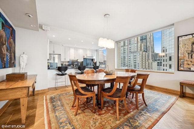 dining space featuring a view of city, recessed lighting, and baseboards