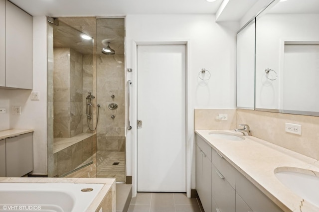 bathroom featuring a sink, double vanity, a shower stall, and tile patterned floors