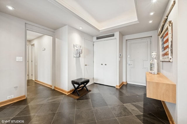 entrance foyer featuring visible vents, recessed lighting, a raised ceiling, and baseboards