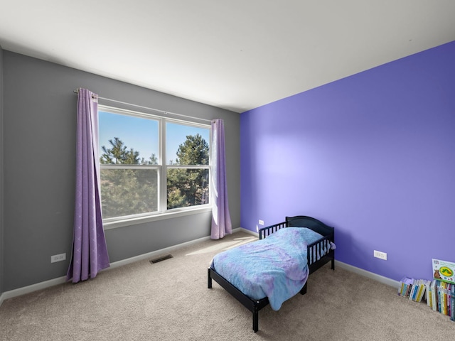 carpeted bedroom with visible vents and baseboards