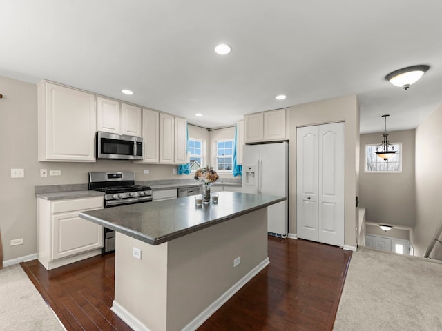 kitchen with recessed lighting, dark wood-style flooring, white cabinets, appliances with stainless steel finishes, and a center island