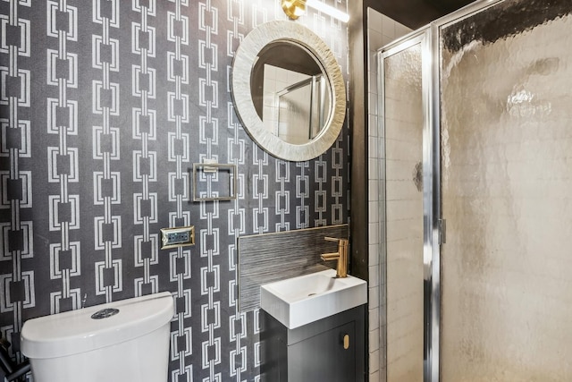 full bath with vanity, toilet, a shower stall, and wallpapered walls