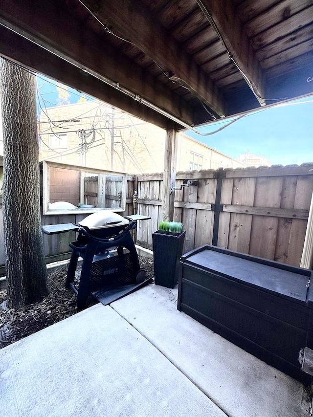 view of patio with a grill and fence