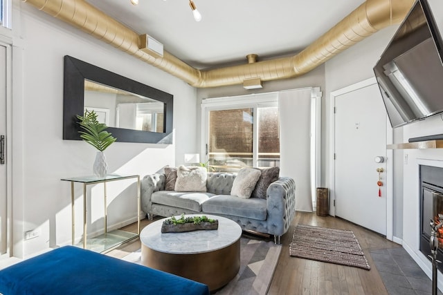 living room featuring a glass covered fireplace and wood finished floors