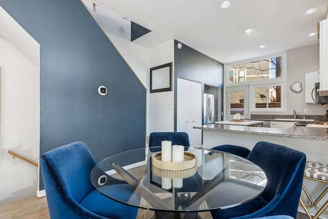 dining space featuring recessed lighting, baseboards, and light wood finished floors