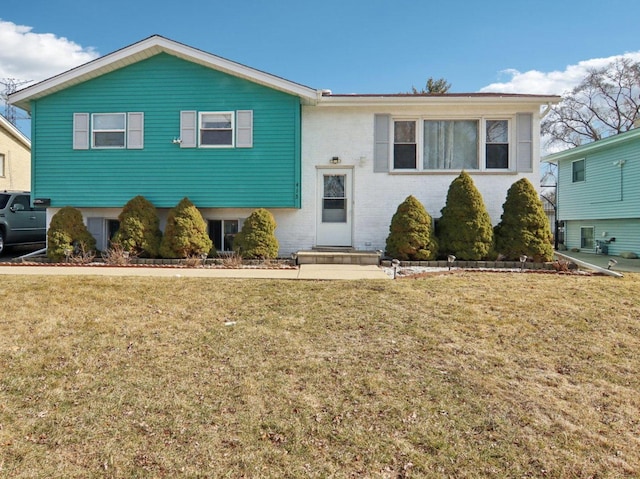 bi-level home featuring brick siding and a front lawn