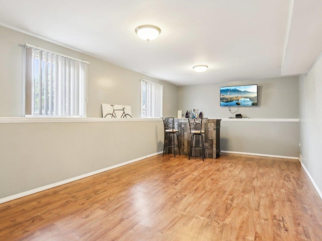 interior space featuring a dry bar, baseboards, and wood finished floors