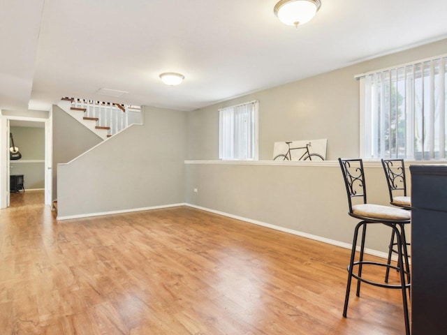 living area with stairs, baseboards, and wood finished floors