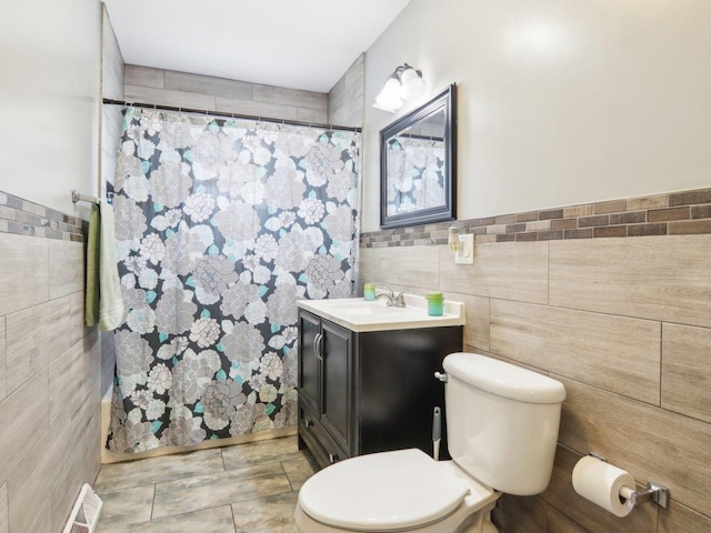 bathroom with vanity, tile walls, toilet, and a shower with curtain