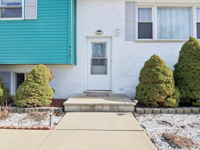 property entrance featuring brick siding