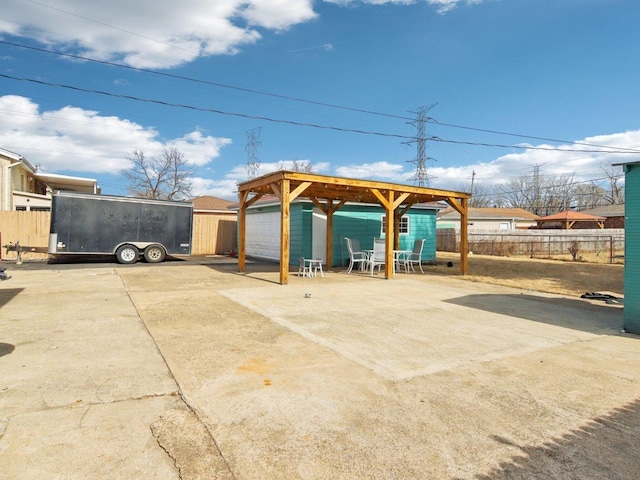 view of patio with an outdoor structure and fence