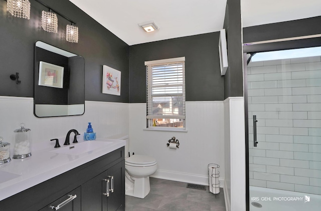 full bathroom with visible vents, tiled shower, toilet, and wainscoting