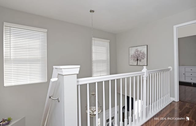 hallway with an upstairs landing and wood finished floors