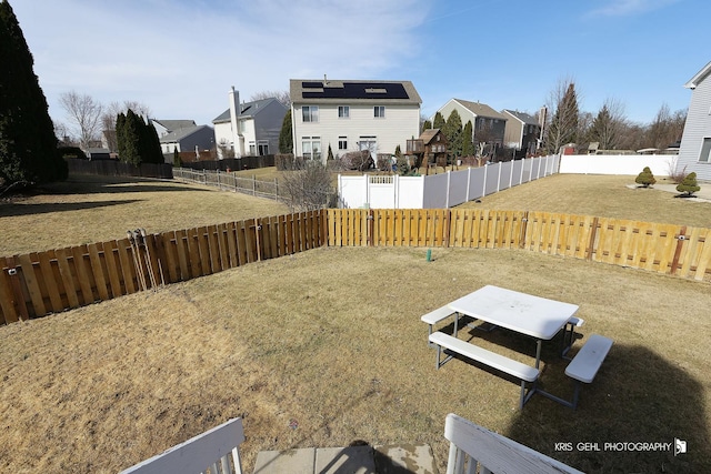 view of yard featuring a fenced backyard and a residential view