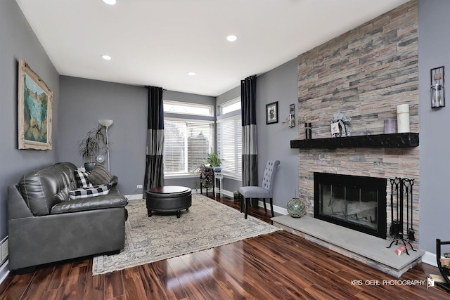 living area with recessed lighting, a fireplace, baseboards, and wood finished floors