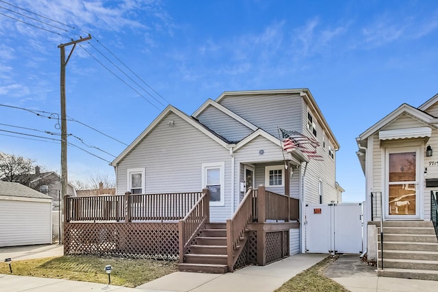 view of front of home featuring entry steps, a deck, and a gate