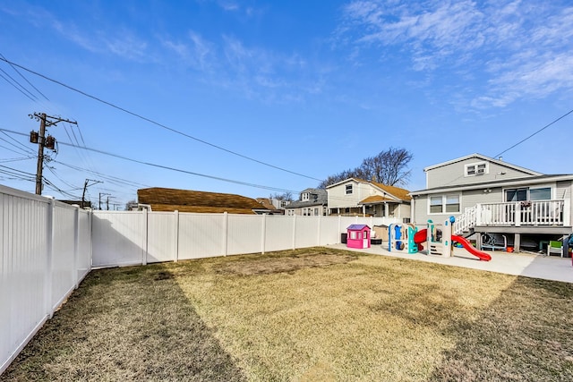 view of yard with a fenced backyard and a playground