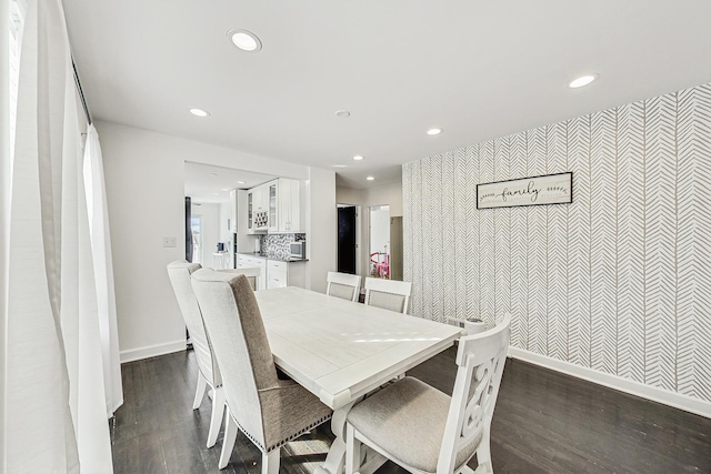 dining room with dark wood finished floors, recessed lighting, an accent wall, and baseboards