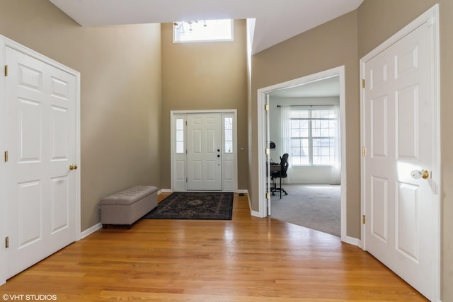 foyer with light wood-type flooring and baseboards