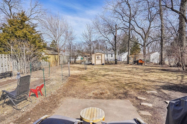 view of yard featuring a storage shed, an outdoor structure, and fence